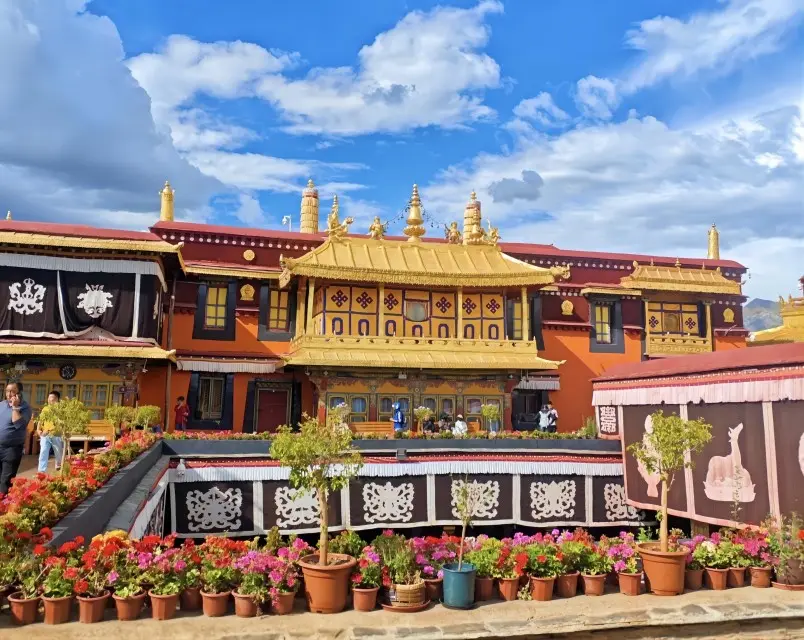 Architectural detail inside Jokhang Temple courtyard in Lhasa, showing traditional Tibetan woodwork and golden roof elements