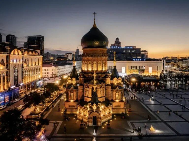 Saint Sophia Cathedral in Harbin illuminated at night with snow-covered square