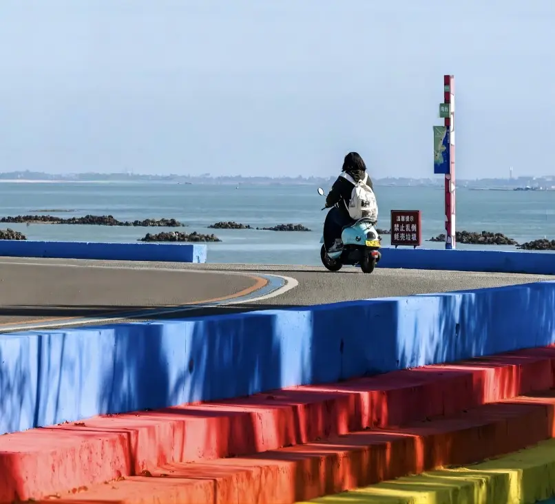 Visitors cycling along the coast of Techeng Island, Zhanjiang