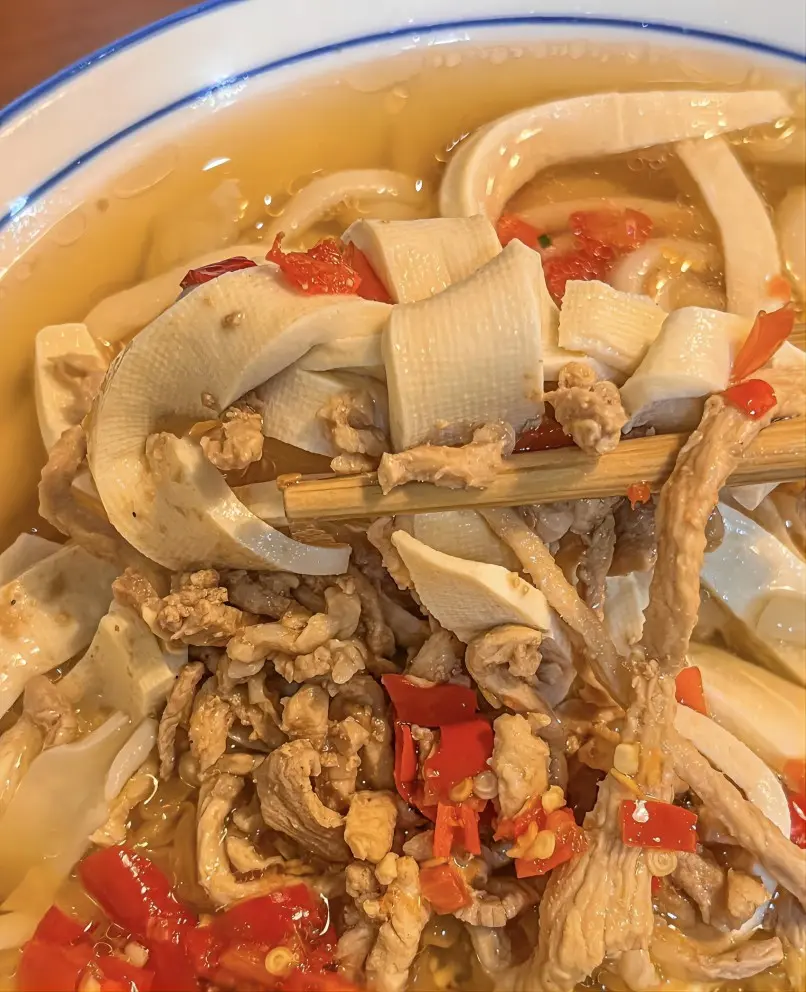 Yiwu Fotang Qian Zhang Noodles, a traditional local dish with bean curd skin and rich bone broth.