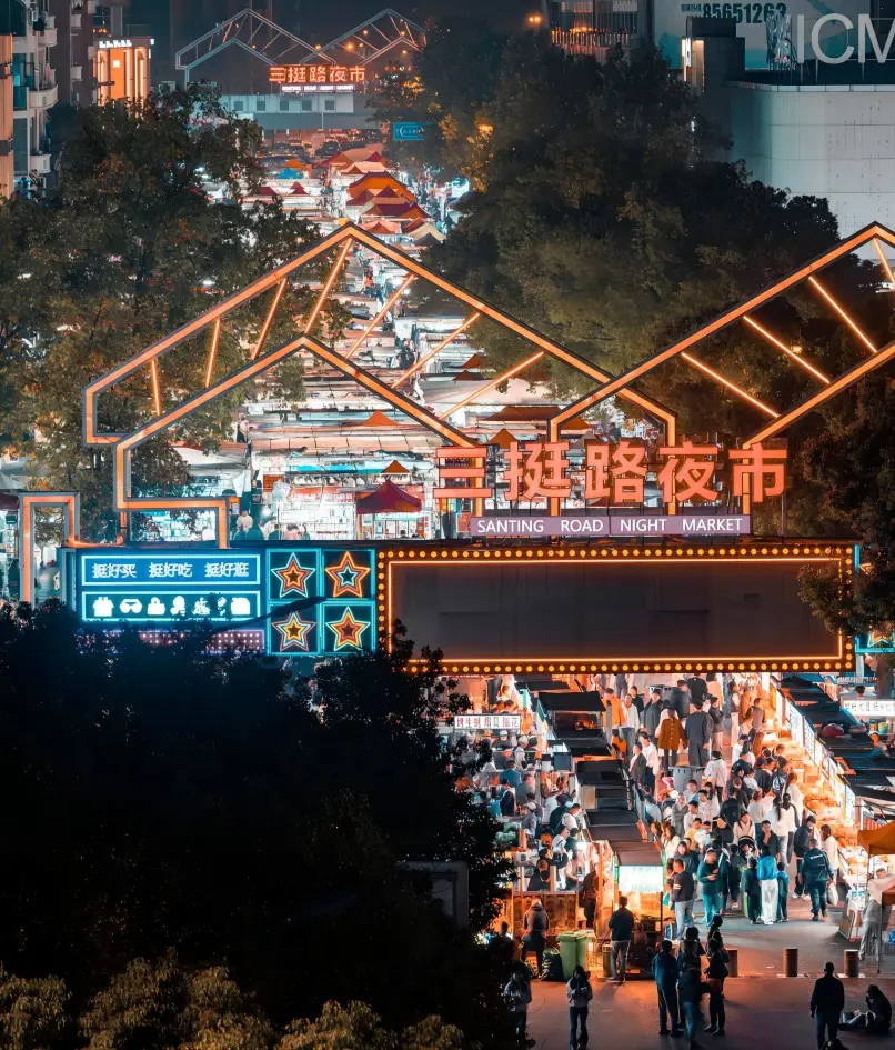 Aerial view of Yiwu Santing Road Night Market, bustling with food stalls and vibrant lights.
