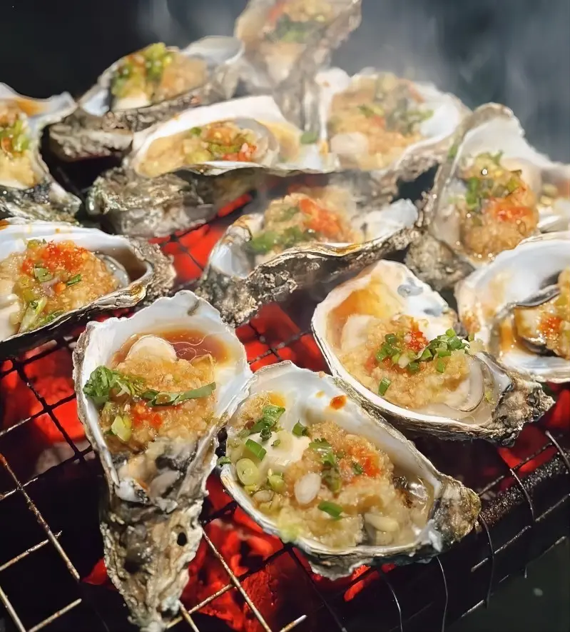 Charcoal-grilled oysters with garlic and chili at a night market in Zhanjiang