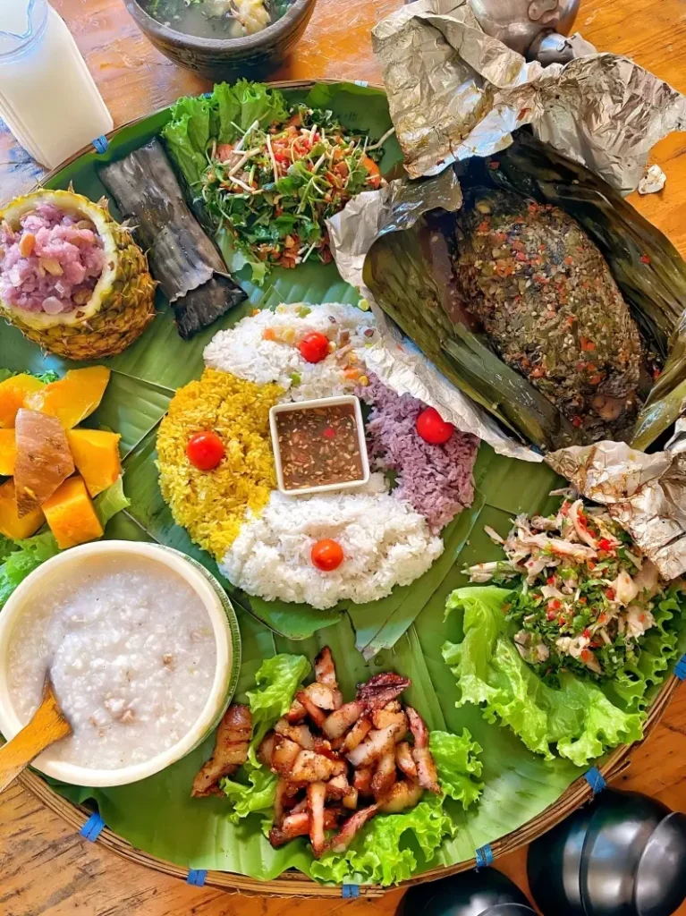 Traditional Dai hand-grab rice feast in Mangshi with grilled meat, vegetables, and sticky rice.