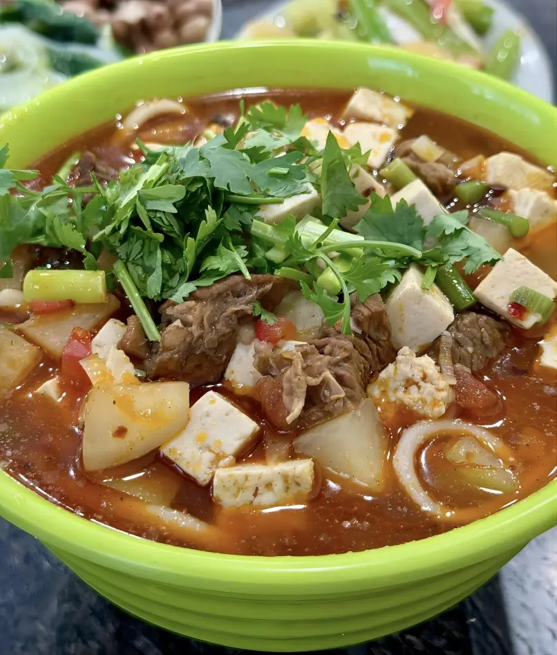 A bowl of hand-pulled lamb noodles (Saozi noodles), served in a flavorful broth with tender lamb and spices.