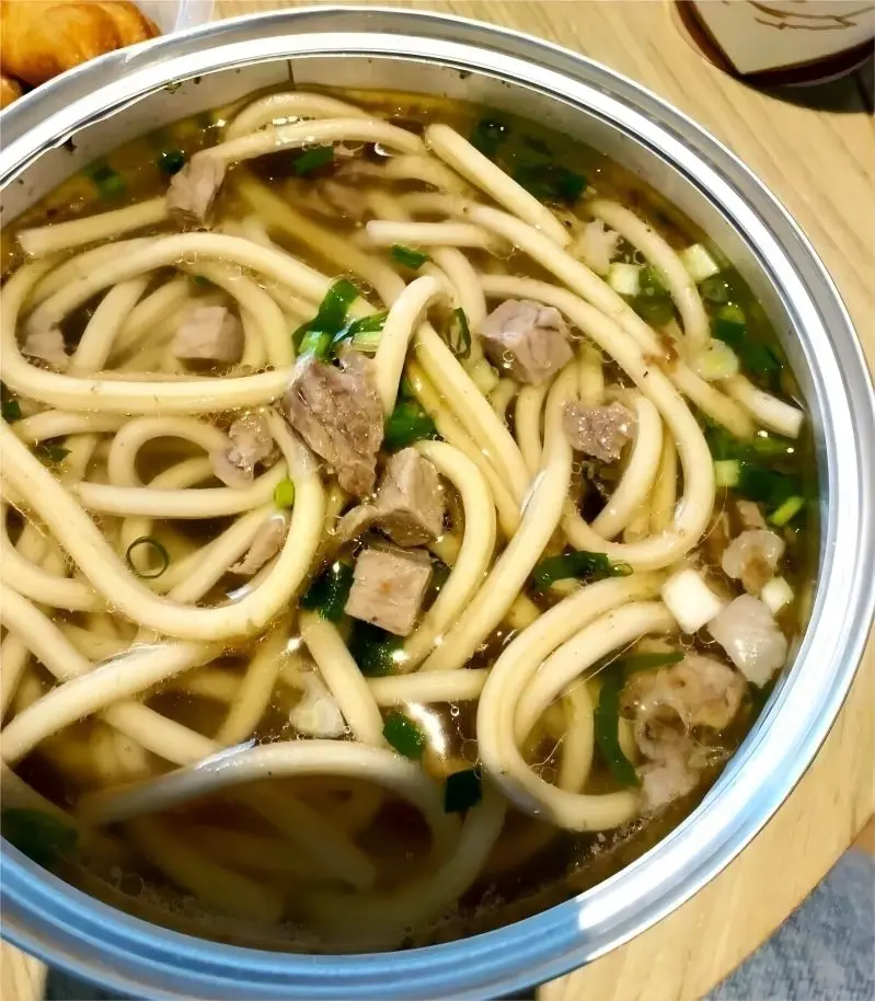 A bowl of Tibetan noodles, served with yak bone soup and yak meat.