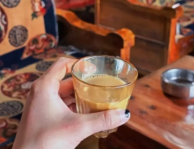 A traditional cup of Tibetan sweet tea, made with tea leaves, milk, and sugar.