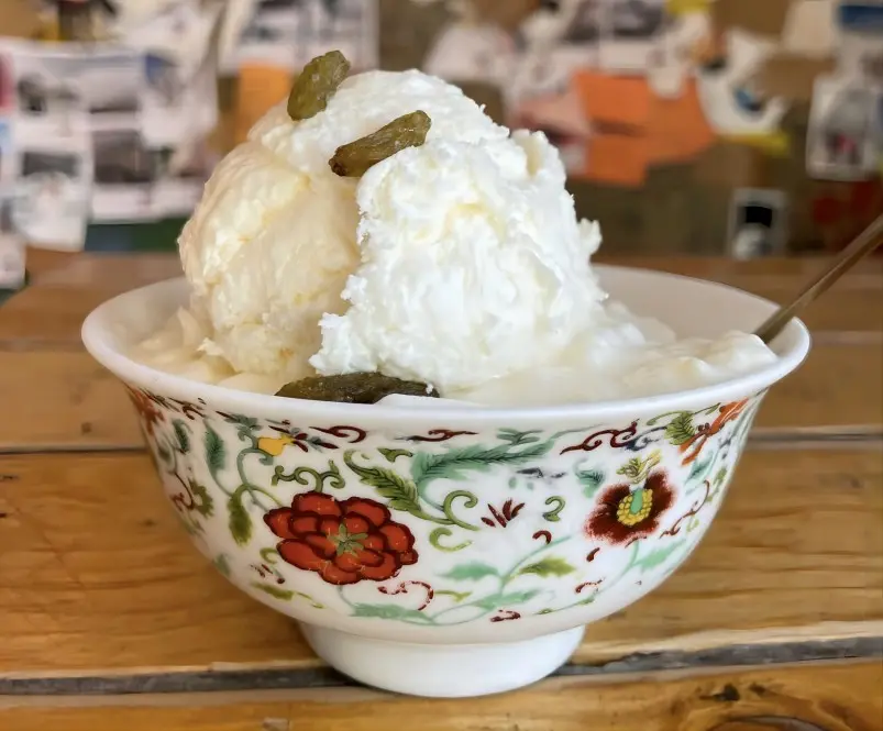 A bowl of traditional Tibetan yogurt made from yak milk, served with honey or sugar.