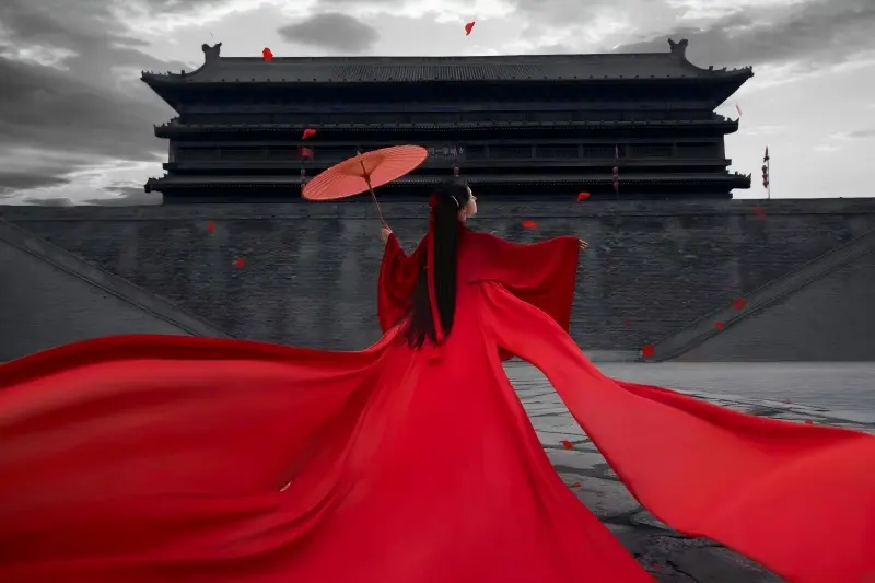 Woman in red Hanfu posing on Xi’an City Wall during sunset