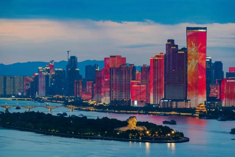Orange Isle in Changsha at dusk, with the modern city skyline visible across the Xiangjiang River.