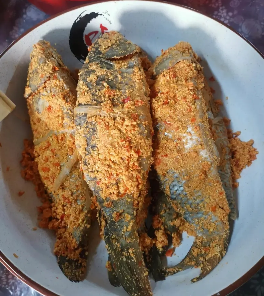 Close-up of traditional Tujia pickled sour fish (Suanzuo Fish), preserved with corn flour and spicy seasonings.