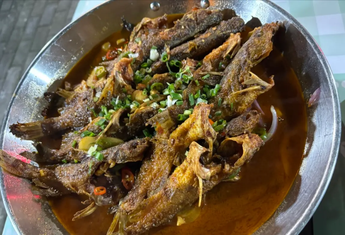 Close-up view of crispy fried rock fish (Yangu Fish), a popular local river fish delicacy in Zhangjiajie.