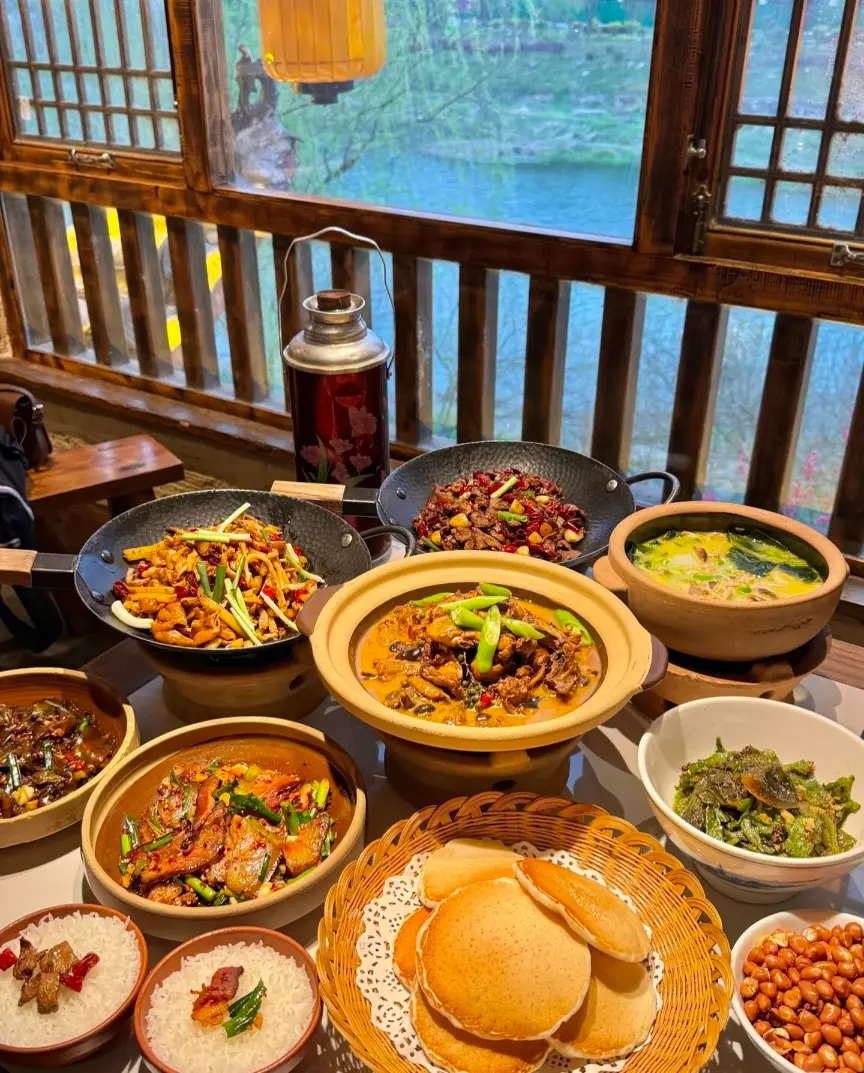 A full table spread of authentic Zhangjiajie local food featuring traditional dishes served in local dining style.