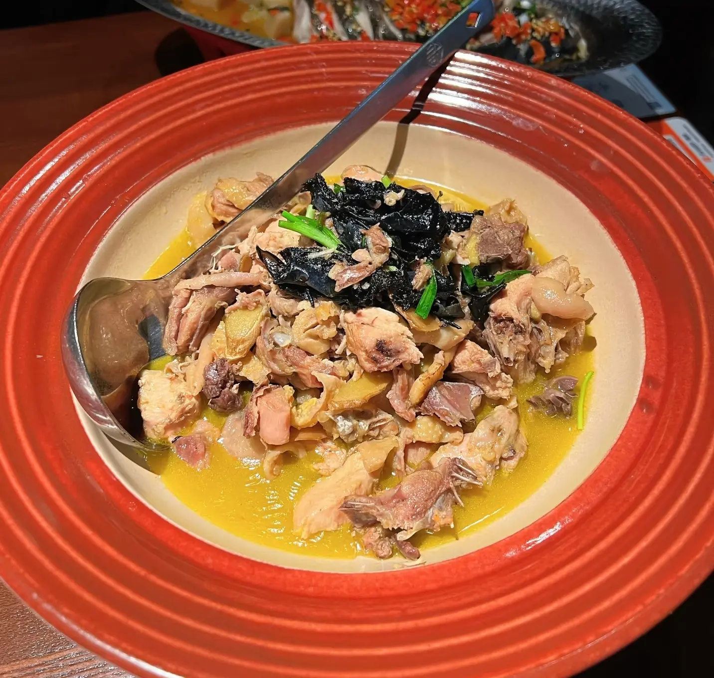 Close-up of rock ear mushroom stewed with local chicken in a rich, flavorful broth, a famous Zhangjiajie delicacy.
