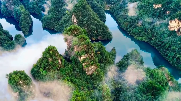 Aerial view of Baofeng Lake surrounded by lush green karst peaks in Suoxiyu, Zhangjiajie