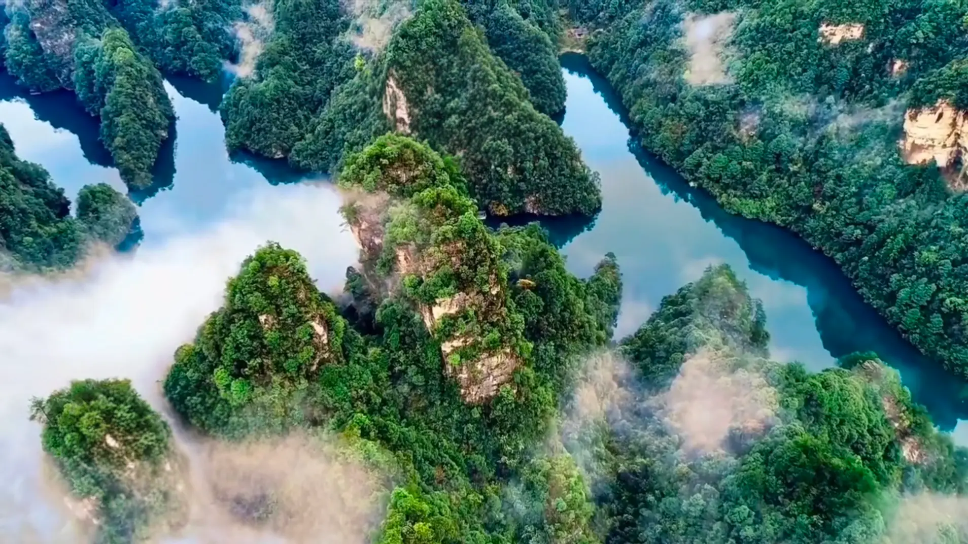 Aerial view of Baofeng Lake surrounded by lush green karst peaks in Suoxiyu, Zhangjiajie